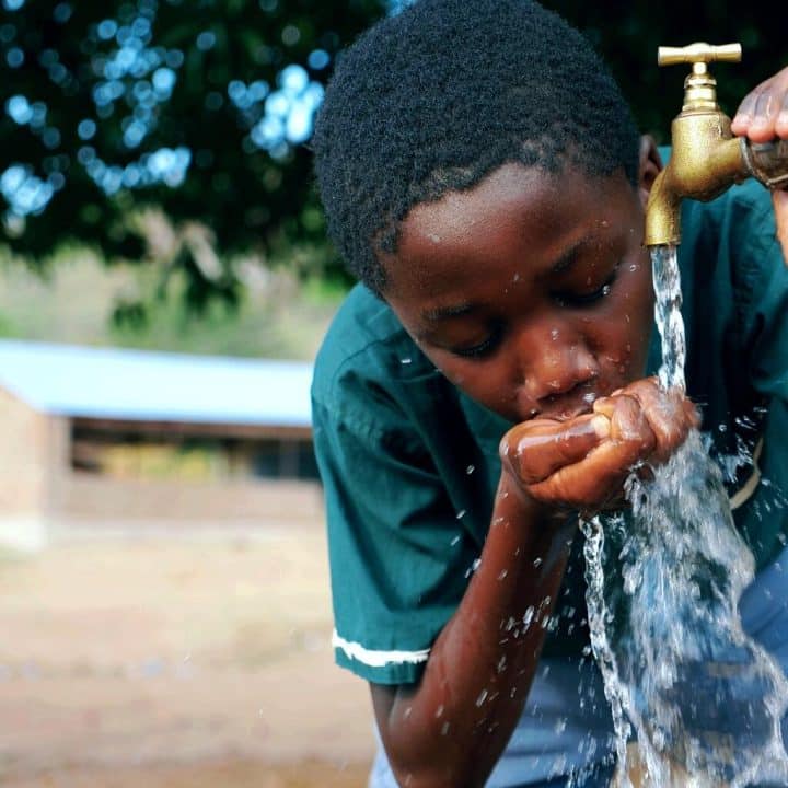 Un élève profite de l'eau potable provenant d'un robinet fourni par l'UNICEF dans le cadre du projet Living schools, le 30 novembre 2020. ©UNICEF/UN0381819