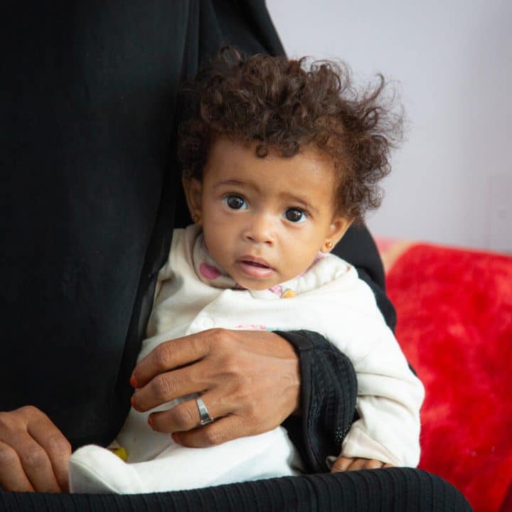 Maryam tient dans ses bras sa fille Anisa, âgée de 9 mois, dans le service de nutrition de l'hôpital Hamdan, à SanaÕa, au Yémen, le 11 octobre 2021. ©UNICEF/UN0536620/Haleem