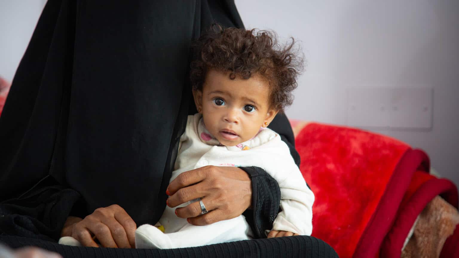 Maryam tient dans ses bras sa fille Anisa, âgée de 9 mois, dans le service de nutrition de l'hôpital Hamdan, à SanaÕa, au Yémen, le 11 octobre 2021. ©UNICEF/UN0536620/Haleem