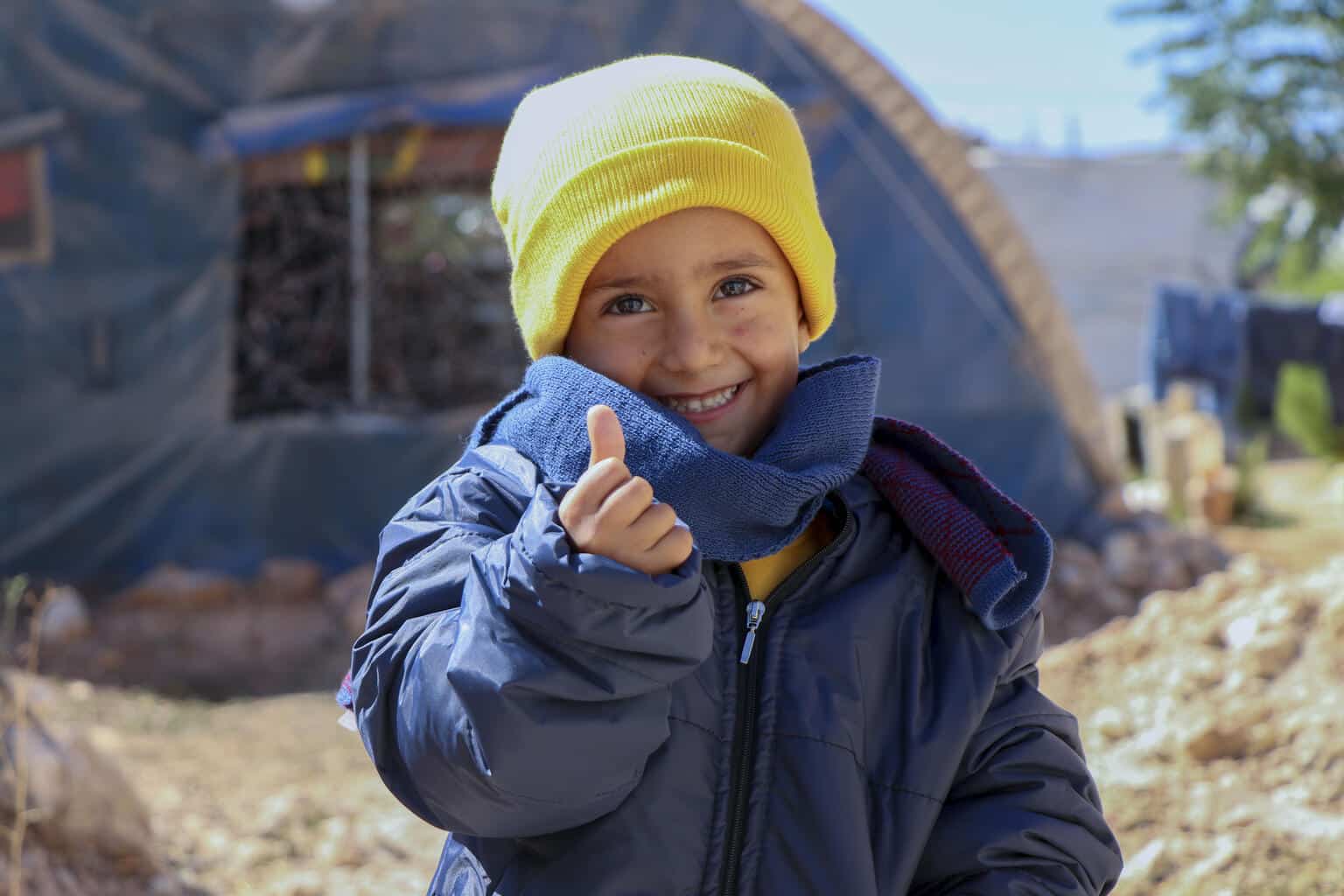 Le 5 octobre 2021, Rashid, 4 ans, est heureux d'avoir des nouveaux vêtements d'hiver. Ils ont distribués par l'UNICEF dans le camp de Fafin, au nord d'Alep.