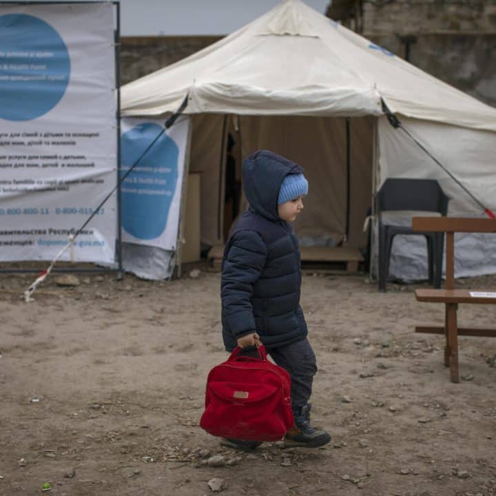 Un garçon passe devant le centre Point bleu de l'UNICEF et du HCR, le 16 mars 2022, dans un centre d'accueil pour réfugiés situé près du poste frontière de Palanca, en Moldavie, près de la frontière Moldavie-Ukraine, après avoir fui la ville ukrainienne d'Odessa. ©UNICEF/UN0609229/Modola