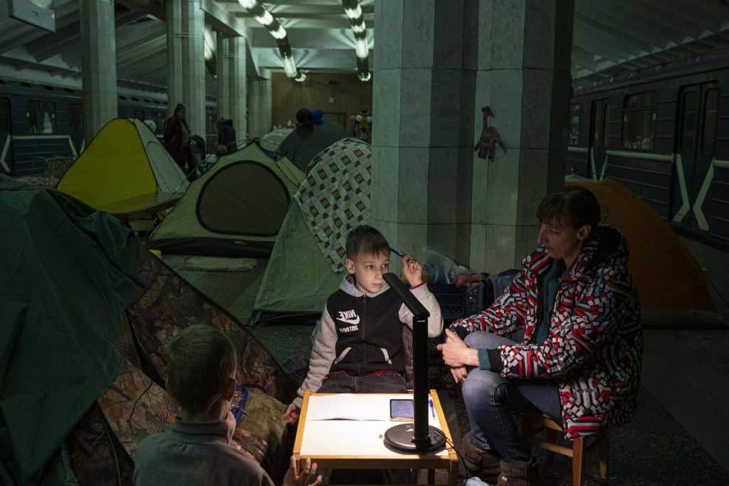 Le 19 avril 2022 en Ukraine, Yura, un élève de deuxième année, fait ses devoirs de mathématiques avec sa mère, Yulia, dans une station de métro de Kharkiv, où les enfants et les familles se sont réfugiés pour échapper au conflit. ©UNICEF/UN0634477/Gilbertson