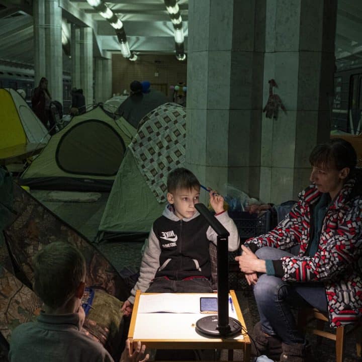 Le 19 avril 2022 en Ukraine, Yura, un élève de deuxième année, fait ses devoirs de mathématiques avec sa mère, Yulia, dans une station de métro de Kharkiv, où les enfants et les familles se sont réfugiés pour échapper au conflit. ©UNICEF/UN0634477/Gilbertson