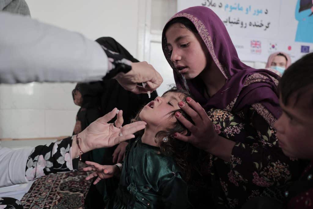 Un jeune garçon reçoit une vaccination orale contre la polio fournie par l'équipe mobile de santé et de nutrition dans le village d'Alisha, dans le district de Shak, dans la province de Wardak, dans la région centrale de l'Afghanistan, le 11 juin 2022.