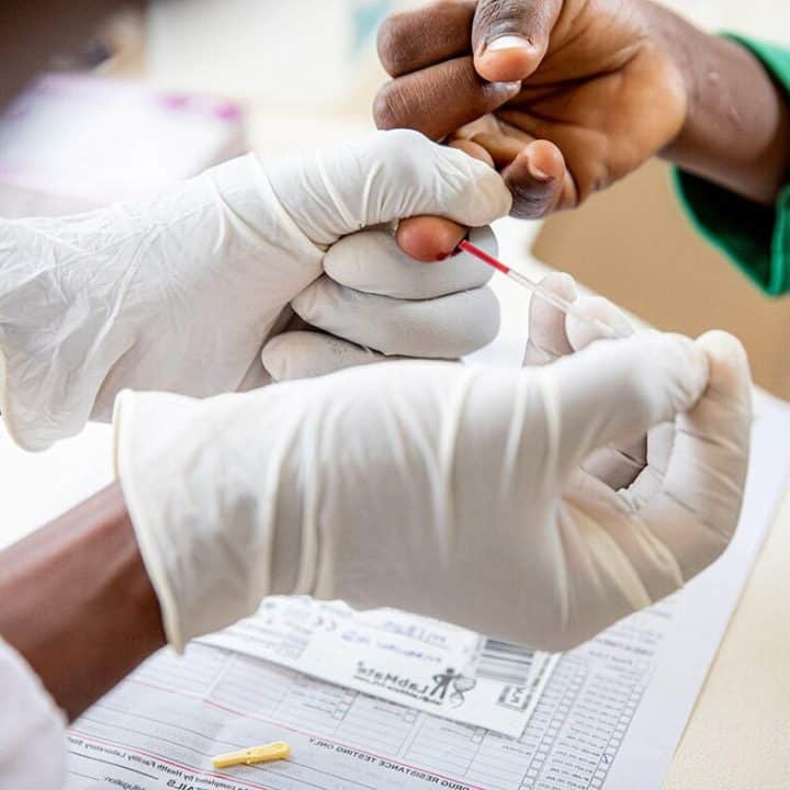 Margret et son fils Ronald (9 ans) sont séropositifs. La charge virale de Ronald est testée par le laboratoire du Madudu Health Facility de Mubende, en Ouganda. Ronald est actuellement sous traitement. © UNICEF/UN0656406/Schermbrucker