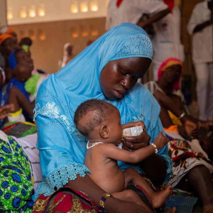 Le 21 juin 2022, au Centre de Santé de Promotion Sociale de Kaya, au Burkina Faso, la mère Sawadogo Abibou, 23 ans, donne du Plumpy Nut à son fils, Abdoul Razack, 6 mois, qui souffre de malnutrition aiguë sévère.