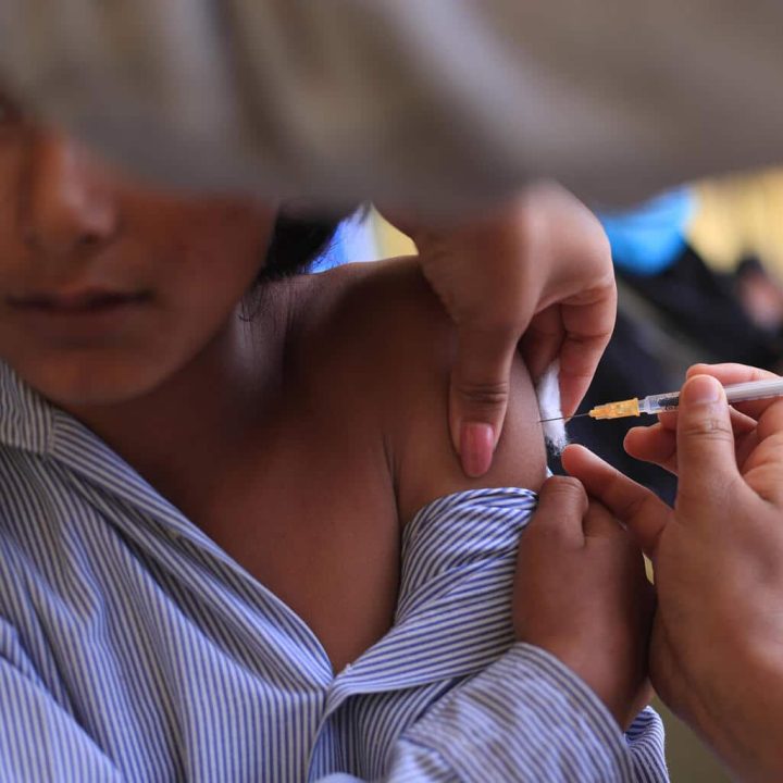 Le 27 juin 2022, un élève de l'école secondaire Mahendra du district de Dadeldhura, dans l'extrême ouest du Népal, reçoit le vaccin COVID-19 dans le cadre de la première phase de la campagne destinée aux enfants âgés de 5 à 11 ans dans 27 districts du pays. © UNICEF/UN0666081/Laxmi Prasad Ngakhusi - CDC