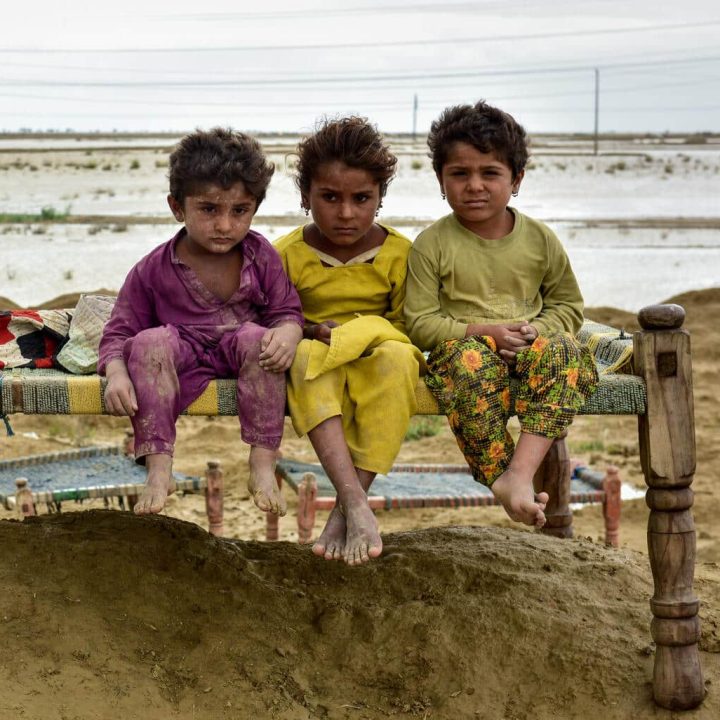Le 18 août 2022, les enfants d'une famille sont assis sur un charpai (lit) après que leur famille ait été déplacée vers un endroit plus sûr suite aux inondations qui ont touché leur village dans le district de Naseerabad, dans la province du Baloutchistan au Pakistan.