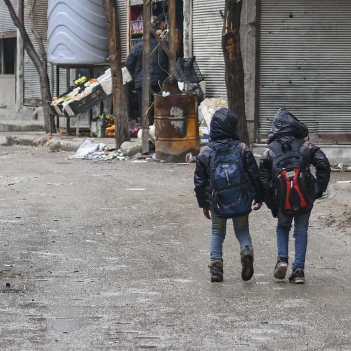 Deux enfants marchent dans la rue à Hammourieh, dans la campagne de Damas, en République arabe syrienne, le 9 janvier 2020. ©UNICEF/UNI289860/Shahan