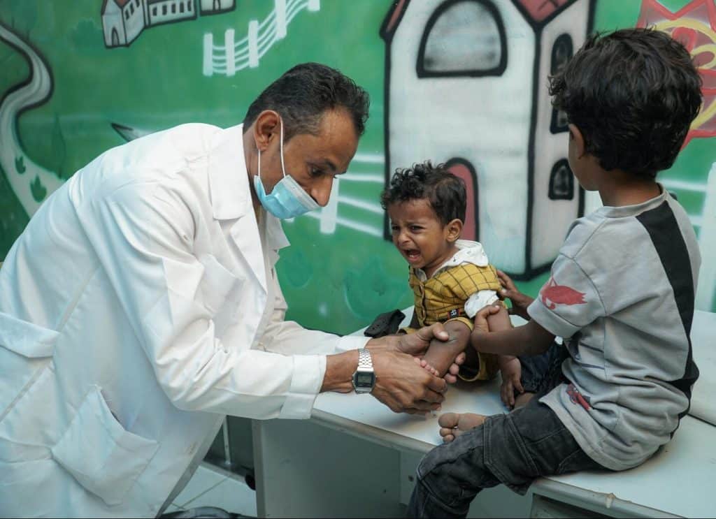 Bassam, 1 an, est examiné par le Dr Mostafa Hassan au centre de prothèses d'Aden, au Yémen, le 14 octobre 2021. ©UNICEF/UN0539887/Noman