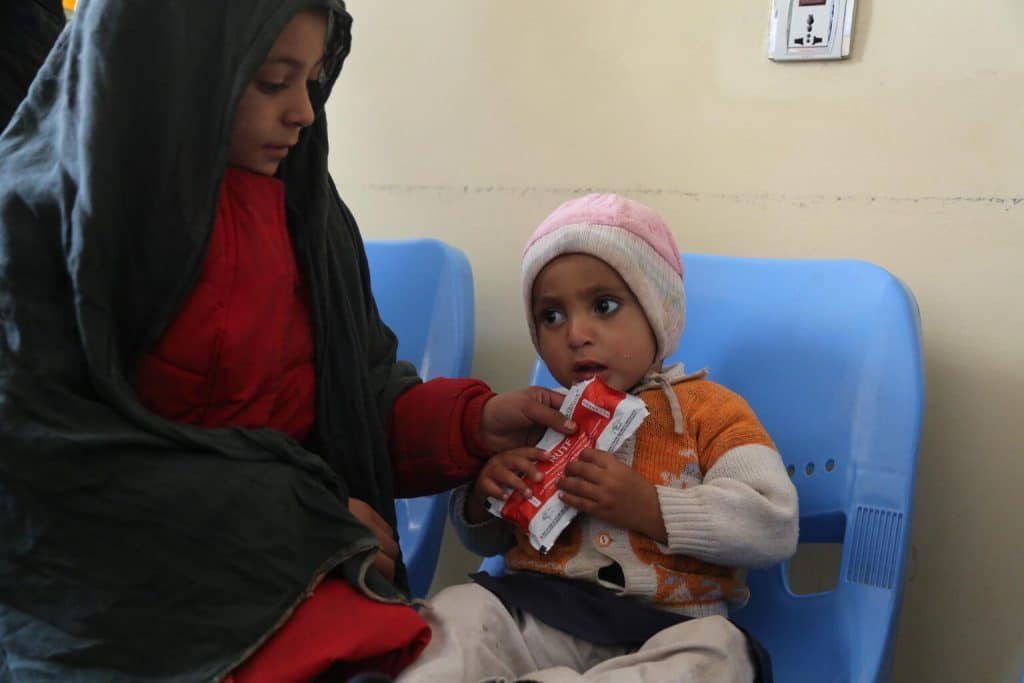 Ehsan Ahmad, 16 mois, mange un sachet d'aliments thérapeutiques prêts à l'emploi (RUTF) dans un centre de santé soutenu par l'UNICEF en Afghanistan.