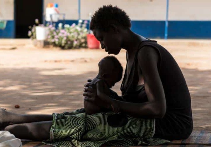 Une jeune maman porte son enfant souffrant de malnutrition dans un centre de soin soutenu par l'UNICEF au Soudan du Sud.