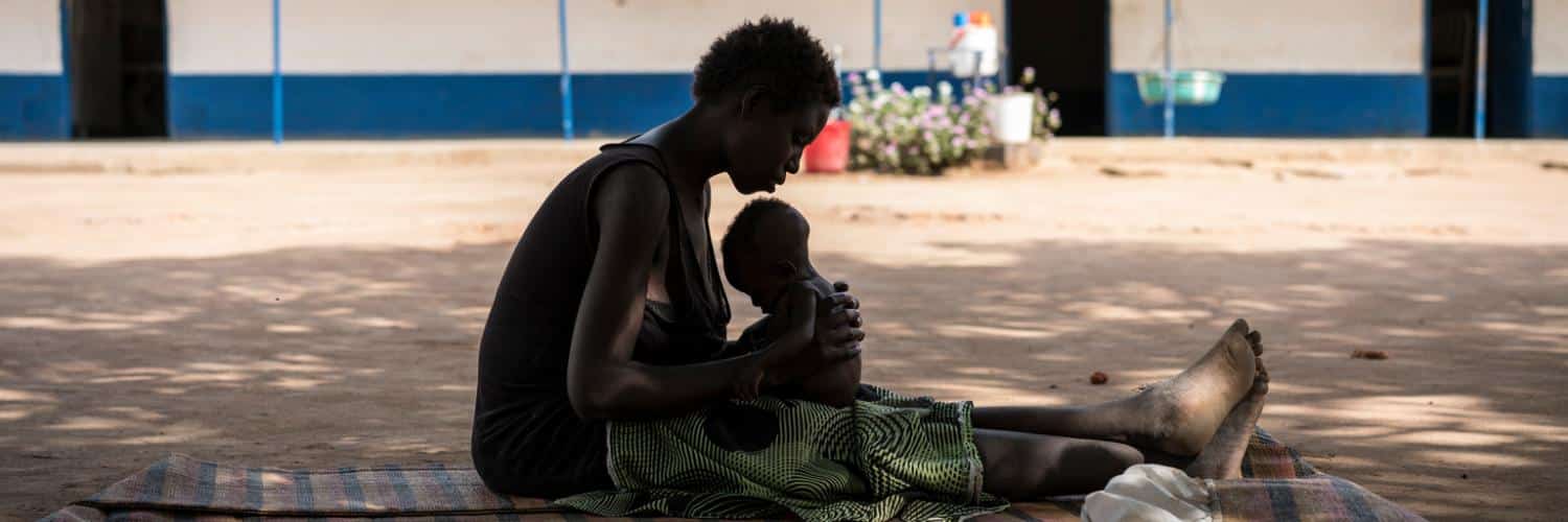 Une jeune maman porte son enfant souffrant de malnutrition dans un centre de soin soutenu par l'UNICEF au Soudan du Sud