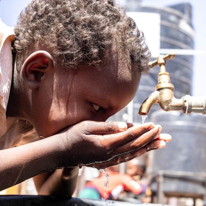 Un garçon boit de l'eau dans la cour de l'école primaire et secondaire de Qansaxleey à Dolow, en Somalie, le 5 février 2022.