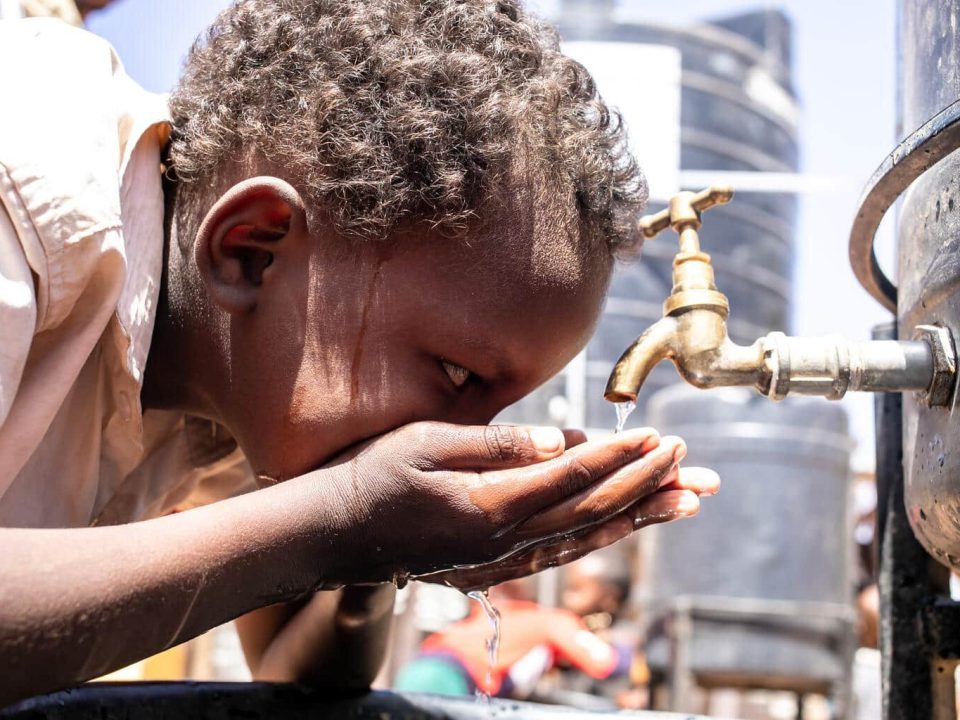 Un garçon boit de l'eau dans la cour de l'école primaire et secondaire de Qansaxleey à Dolow, en Somalie, le 5 février 2022.