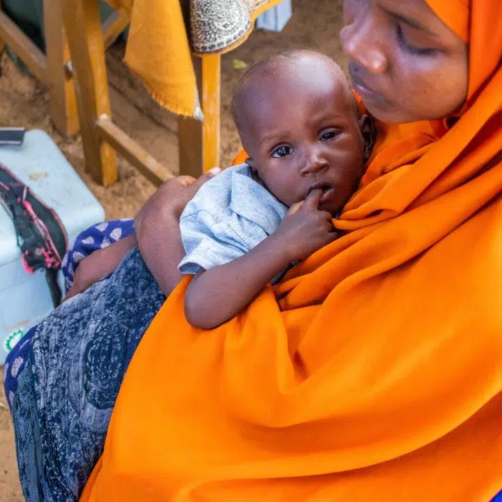 Ayesha tient son bébé dans les bras, dans le camps de Wafi en Somalie, le 13 juin 2022. © UNICEF/UN0663317/Sewunet