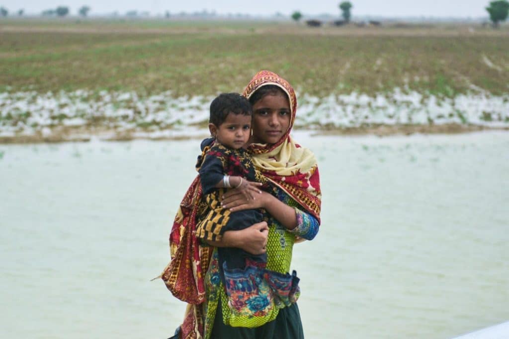 Le 18 août 2022, une petite fille tient sa soeur dans ses bras. Les enfants ont été déplacés par les pluies torrentielles et les inondations dans l'Union Council Chattar, district de Naseerabad, Balochistan, Pakistan. ©UNICEF/UN0694840/Malik