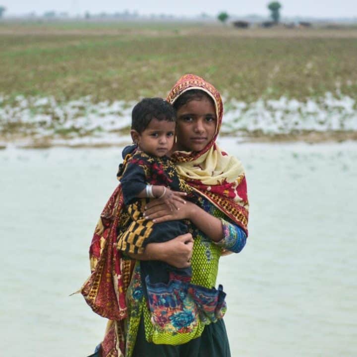 Le 18 août 2022, une petite fille tient sa soeur dans ses bras. Les enfants ont été déplacés par les pluies torrentielles et les inondations dans l'Union Council Chattar, district de Naseerabad, Balochistan, Pakistan. ©UNICEF/UN0694840/Malik
