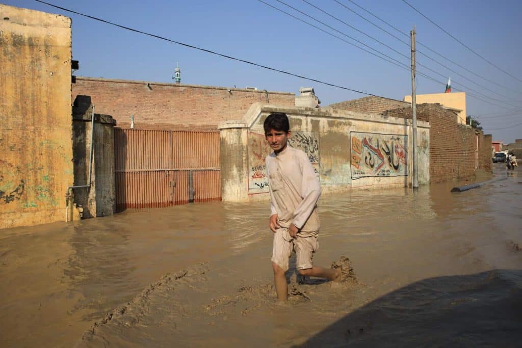 Le 30 août 2022, un enfant patauge dans une rue inondée dans la province de Khyber Pakhtunkhwa, au Pakistan. ©UNICEF/UN0696411/Moin