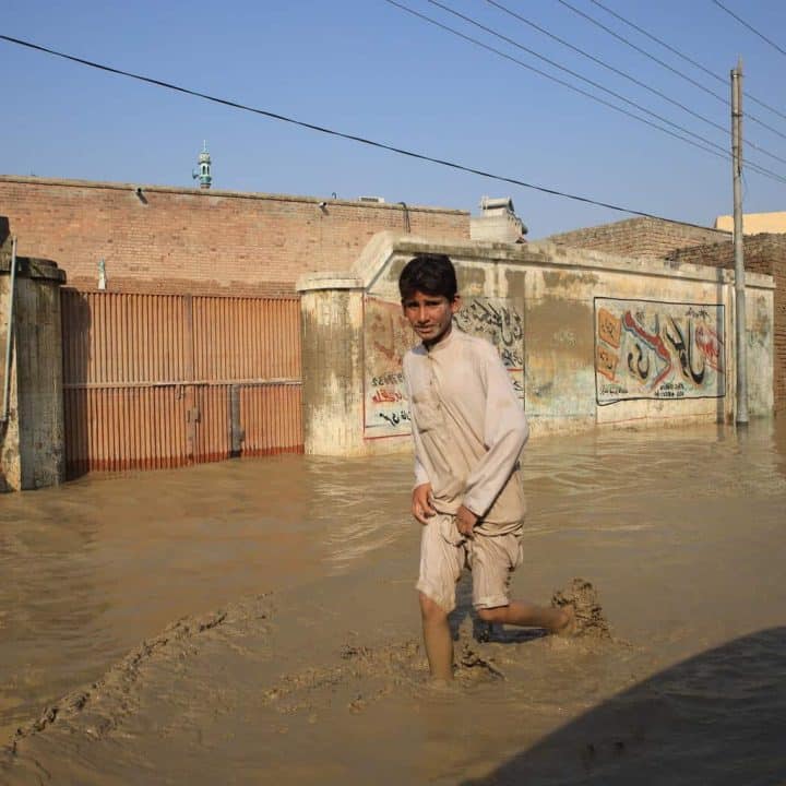 Le 30 août 2022, un enfant patauge dans une rue inondée dans la province de Khyber Pakhtunkhwa, au Pakistan. ©UNICEF/UN0696411/Moin