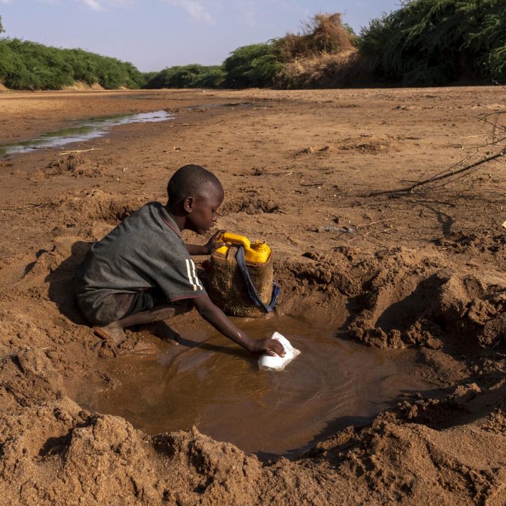 Un jeune garçon récupère le peu d'eau qu'il peut trouver dans une rivière tarie en raison de la sécheresse qui frappe la Somalie. © UNICEF/UN0607653/Rich