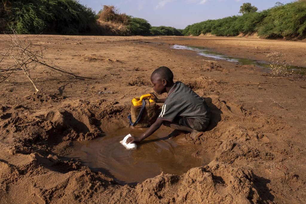 Un jeune garçon récupère le peu d'eau qu'il peut trouver dans une rivière tarie en raison de la sécheresse qui frappe la Somalie. © UNICEF/UN0607653/Rich