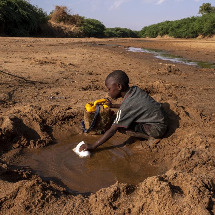 Un jeune garçon récupère le peu d'eau qu'il peut trouver dans une rivière tarie en raison de la sécheresse qui frappe la Somalie. © UNICEF/UN0607653/Rich