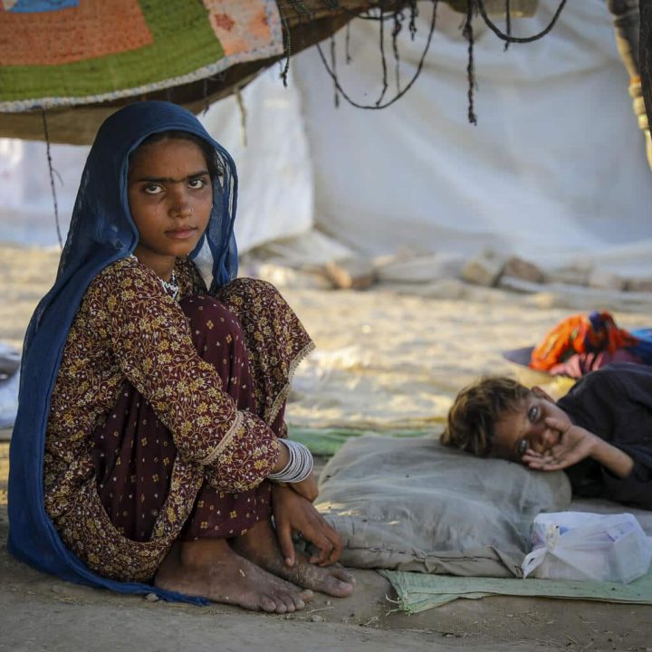 Le 10 septembre 2022, Naz Gul, 11 ans, est assise à côté de son frère Shahzain, 7 ans, qui souffre d'une forte fièvre, au bord de la route dans le district de Jacobabad, dans la province du Sindh, au Pakistan. © UNICEF/UN0702906/Zaidi