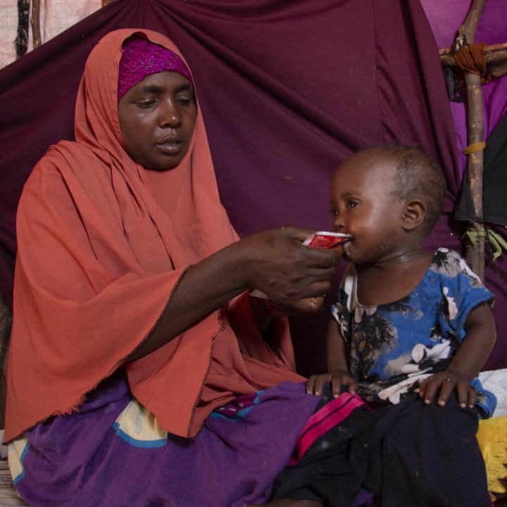 Le 21 septembre 2022 à Mogadiscio, Khadijo Mohamed Aden nourrit sa fille Sabirin, âgée de deux ans, avec des aliments thérapeutiques prêts à l'emploi. © UNICEF/UN0719418/Yusuf