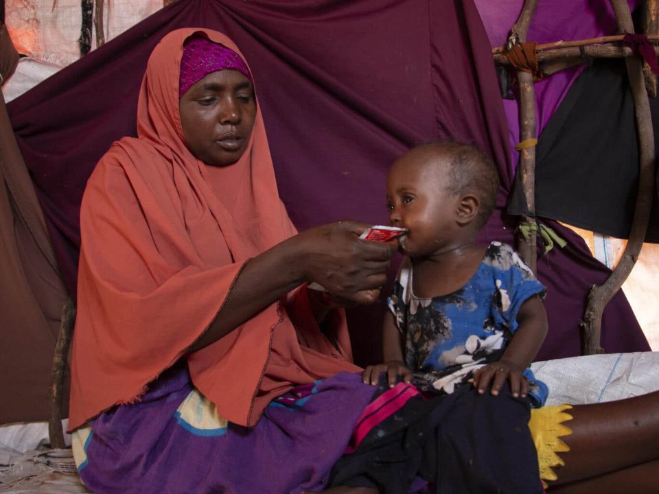 Le 21 septembre 2022 à Mogadiscio, Khadijo Mohamed Aden nourrit sa fille Sabirin, âgée de deux ans, avec des aliments thérapeutiques prêts à l'emploi. © UNICEF/UN0719418/Yusuf