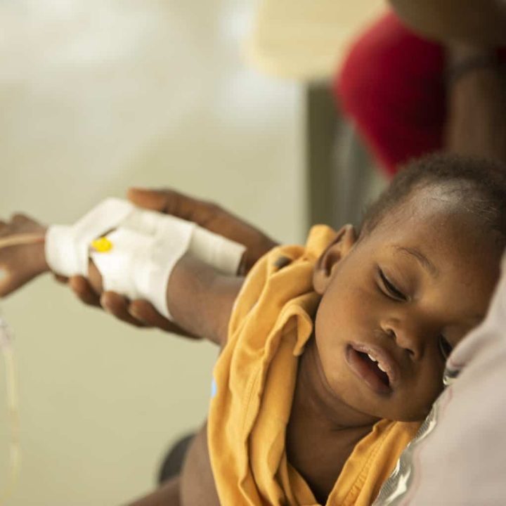 Un jeune enfant avec une perfusion collée à sa main dormant sur son lit alors qu'il souffre des symptômes du choléra au Centre Gheskio de Port-au-Prince, en Haïti, vendredi 14 octobre 2022. © UNICEF/UN0721018/Joseph