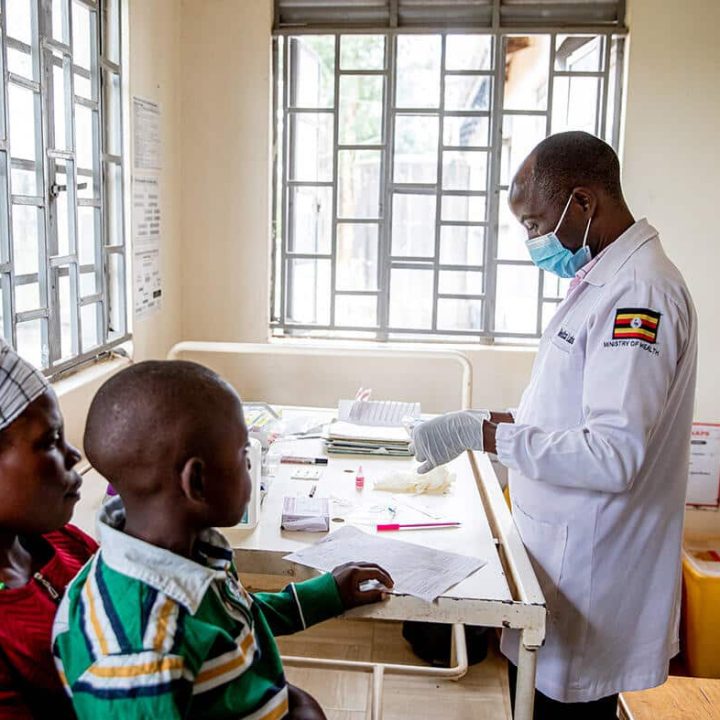 Margret et son fils Ronald (9 ans) sont atteints du VIH. La charge virale de Ronald est testée par le laboratoire du Madudu Health Facility de Mubende, en Ouganda. Ronald est actuellement sous traitement. © UNICEF/UN0656510/Schermbrucker