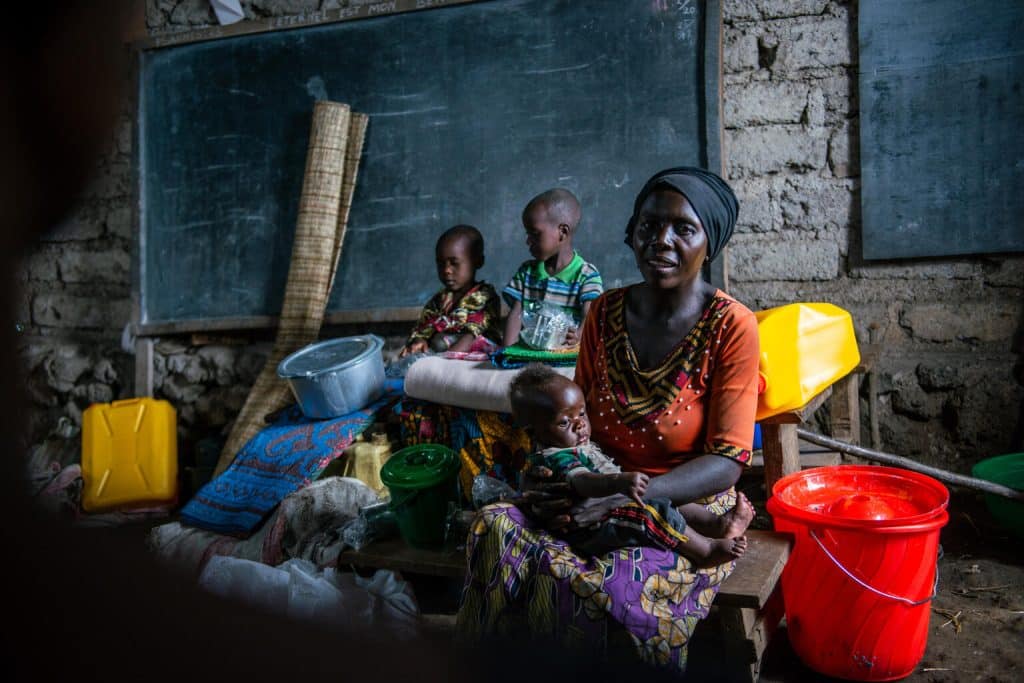 Jeanine Furaha a trouvé refuge dans un site pour personnes déplacées à Kalengera avec ses trois enfants après avoir fui les affrontements armés dans la province du Nord-Kivu en RD Congo. Elle a reçu des fournitures d'urgence grâce au programme de réponse rapide UniRR mis en place par l'UNICEF par l'intermédiaire de la Croix-Rouge. © UNICEF/UN0686966/Bashizi