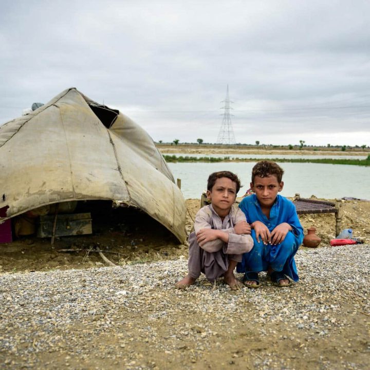 Le 18 août 2022, des enfants sont assis à côté de leur abris de fortune après avoir fui les inondations qui ont frappé les villages du district de Naseerabad, dans la province du Baloutchistan au Pakistan. ©UNICEF/Pakistan22/Sami Malik