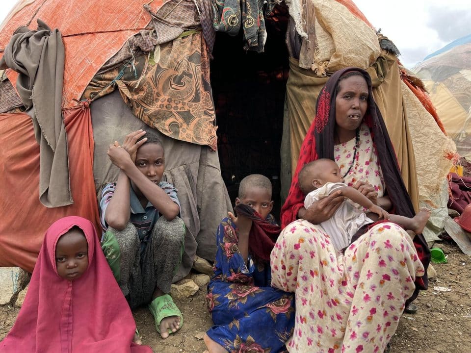 Le 29 septembre 2022, Fatuma et ses enfants sont assis à l'extérieur de leur tente de fortune dans le camp de personnes déplacées de Hagarka à Baidoa, dans la région de la Baie du Sud de la Somalie. © UNICEF/UN0723457/Giri