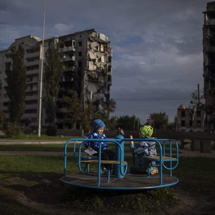 Photo d'illustration prise le 29 septembre 2022 en Ukraine où des enfants jouent près de bâtiments détruits à Borodyanka en raison des bombardements.