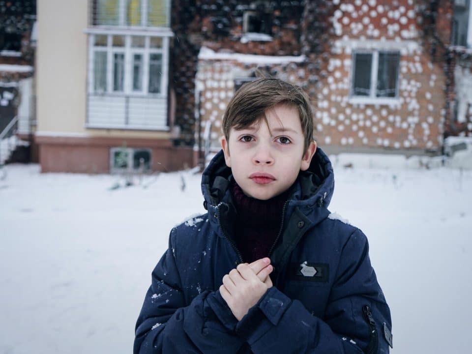 Le 14 décembre 2022, Zhenya, 7 ans, pose pour une photo devant sa maison à Irpin, dans la région de Kiev, en Ukraine. © UNICEF/UN0760448/Hrom