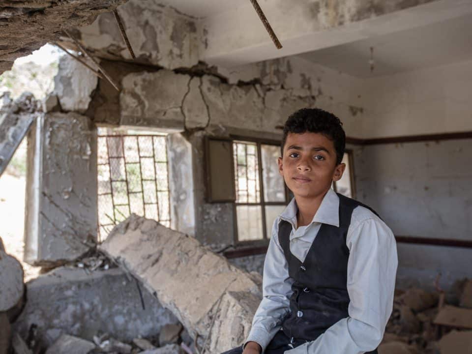 Ahmed, 12 ans, est assis sur les décombres de son école, l'école Al-Hamzi, à Hajjah au Yémen, mars 2021. © UNICEF/UN0459558/Marish