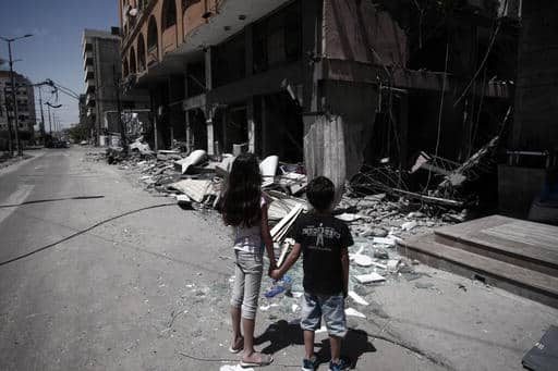 Le 17 mai 2021, à Gaza, une petite fille et un petit garçon palestiniens se tiennent devant leur maison alors que leur famille récupère les biens laissés à l'intérieur de la maison endommagée après avoir été prise pour cible. ©UNICEF/UN0464418/El Baba