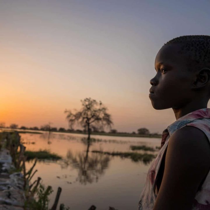 Ayak, 13 ans, marche devant des eaux inondées près du village de Panyagor à Twic East, dans l'État de Jonglei, au Sud-Soudan. © UNICEF/UN0594304/Naftalin