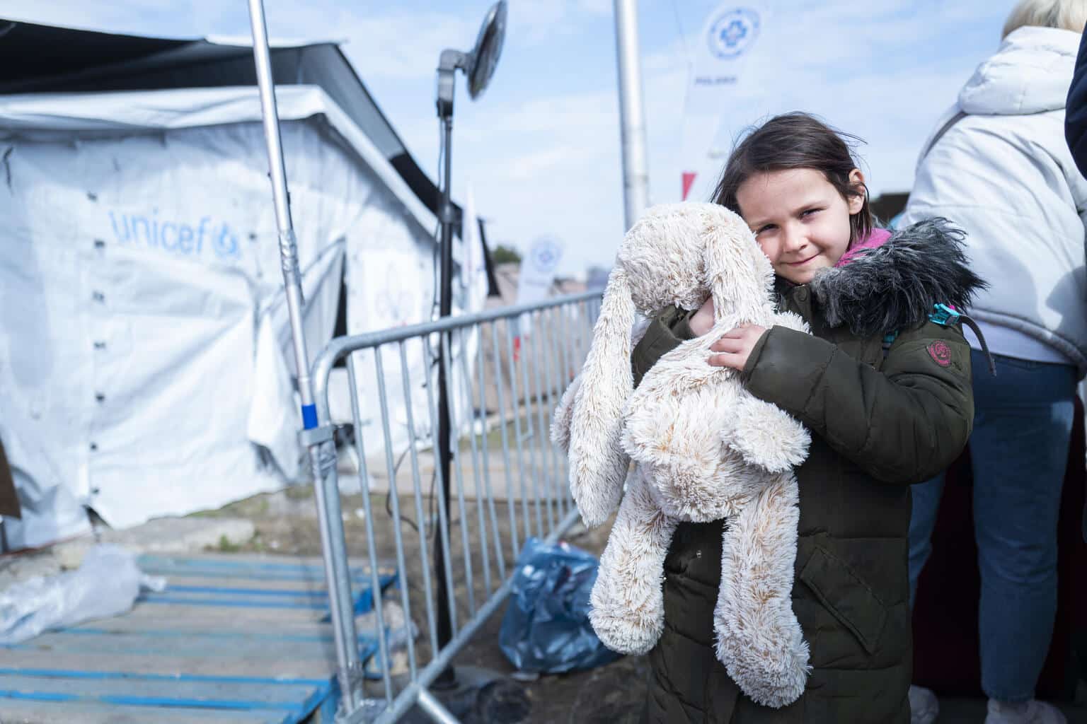 Le 25 mars 2022, Nastja, 7 ans, prends dans ses bras son jouet préféré, un gros lapin en peluche, près de la tente de l'UNICEF à la frontière de Medyka (Pologne) après avoir fui le conflit en Ukraine. © UNICEF/UN0623746/Korta