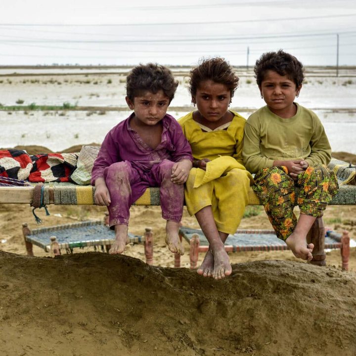 Le 18 août 2022, des enfants d'une famille s'assoient sur un charpai (lit) après le déplacement de leur communauté vers un endroit plus sûr suite aux inondations qui ont touché leur village dans le district de Naseerabad, dans la province du Baloutchistan au Pakistan. ©UNICEF/Pakistan22/Sami Malik