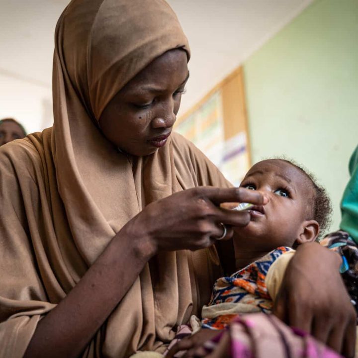 Fatima Muhammad réalise un test d'appétit LNS pour sa fille Aisha Muba, âgée de 7 mois, au centre de soins de santé primaires Malam Sidi Madaki, dans la zone de gouvernement local de Kwami, dans l'État de Gombe. © UNICEF/UN0725032/Apochi Owoicho