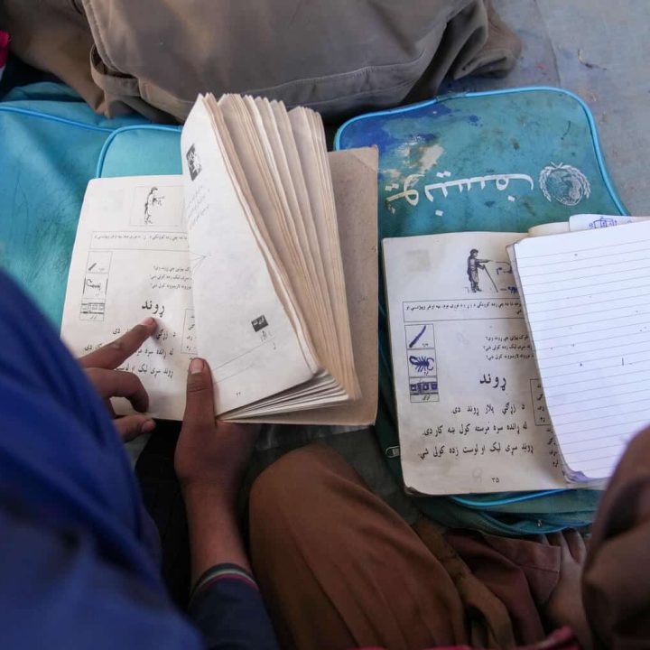 Le 22 novembre 2022, un groupe de garçons et de filles lisent dans leurs livres de leçons dans une classe d'éducation communautaire soutenue par l'UNICEF dans le district de Spera, en Afghanistan. © UNICEF/UN0743117/Gripiotis