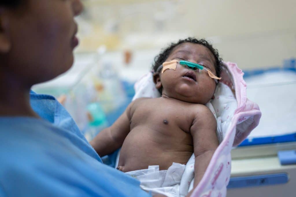 Sarah Mohamed, 20 ans, tient son enfant Omnia, âgé de 20 jours, dans une chambre isolée de l'unité de soins intensifs néonatals (USIN) de l'hôpital Saad Abu Alela, situé dans la banlieue de Khartoum. © UNICEF/UN0746957/Mojtba Moawia Mahmoud