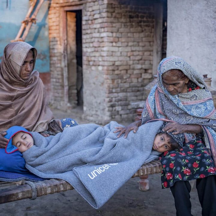 Des grands-mères gardent leurs petits-enfants au chaud à l'aide de couvertures fournies par l'UNICEF dans le village de Zangi Brohi, district de Dadu, Sindh. © UNICEF/UN0761229/Butt