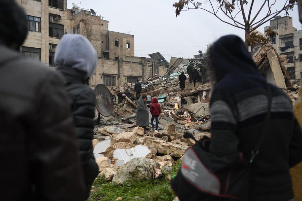 Le 6 février 2023, des personnes se rassemblent autour de bâtiments effondrés tandis que les équipes de secours cherchent des survivants après un tremblement de terre dans la ville syrienne d'Alep. © UNICEF/UN0777950/AFP