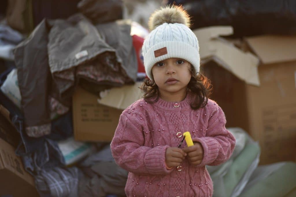 Une petite fille se tient parmi les boîtes de fournitures envoyées aux survivants du tremblement de terre de magnitude 7,7 à Kahramanmaraş, Türkiye. © UNICEF/UN0781435/Ölçer