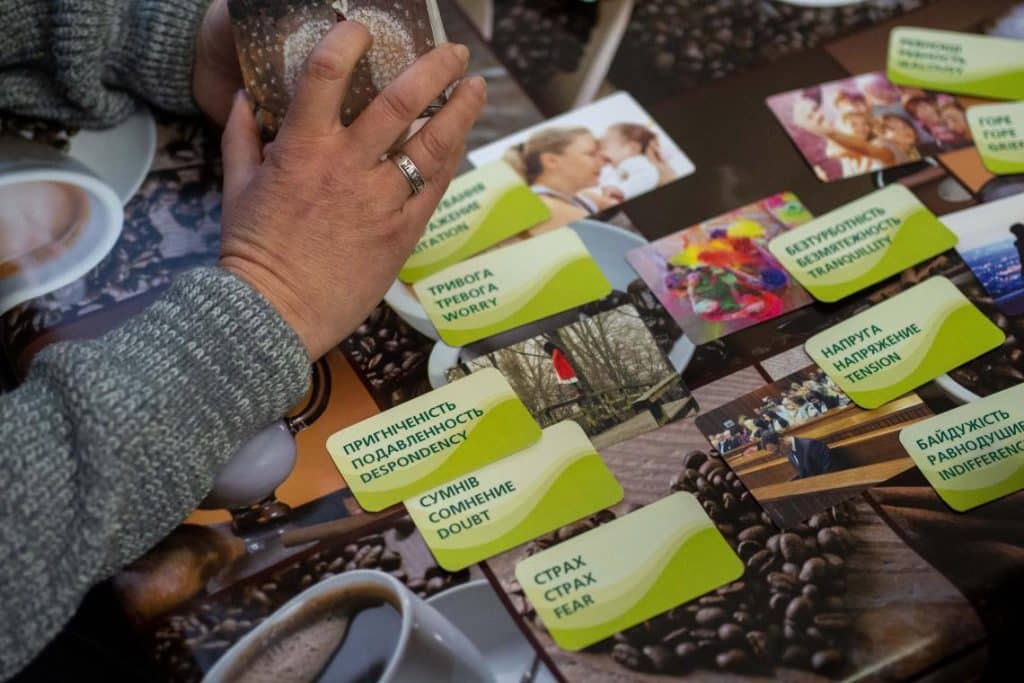 Tension, indifférence et anxiété - ce sont les trois émotions que Dasha choisit parmi les cartes présentées par le psychologue de l'équipe pour décrire les derniers mois. © UNICEF/UN0773887/Filippov