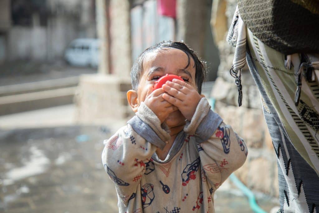 Le petit Rayan , âgé de 2 ans et demi, dans le quartier d'Al Nusayria - district d'Al Mudhaffar - gouvernorat de Taizz, est heureux de boire de l'eau et de célébrer l'arrivée de l'eau dans son quartier. © UNICEF/UN0610688/Al-Basha